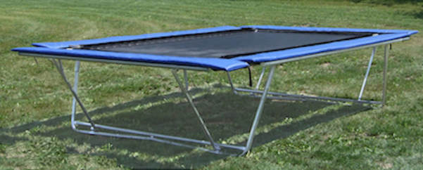 Backyard Pro trampoline is shown outside on a lawn in its aboveground mode. It can also convert to a ground-level installation.